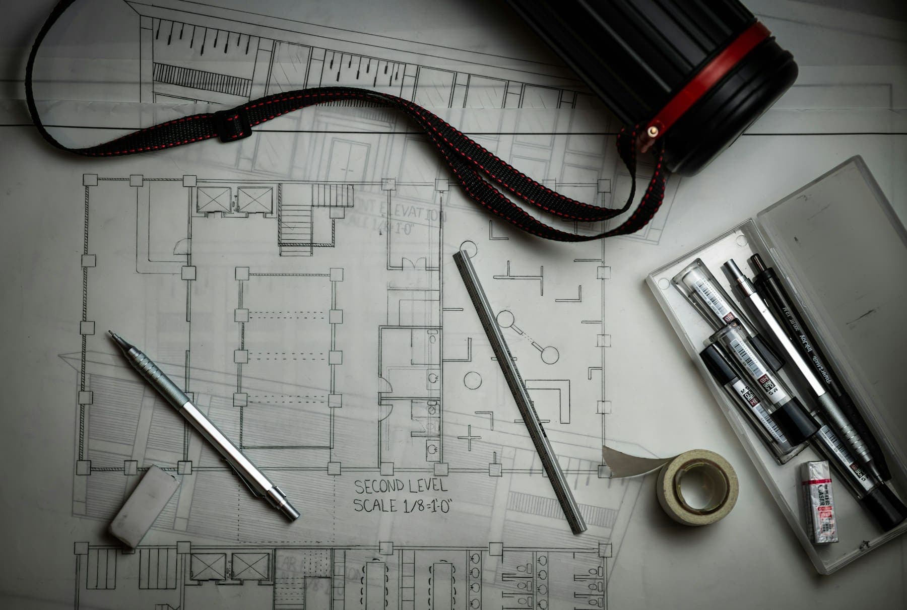 Architectural plans with drafting pencils and a ruler