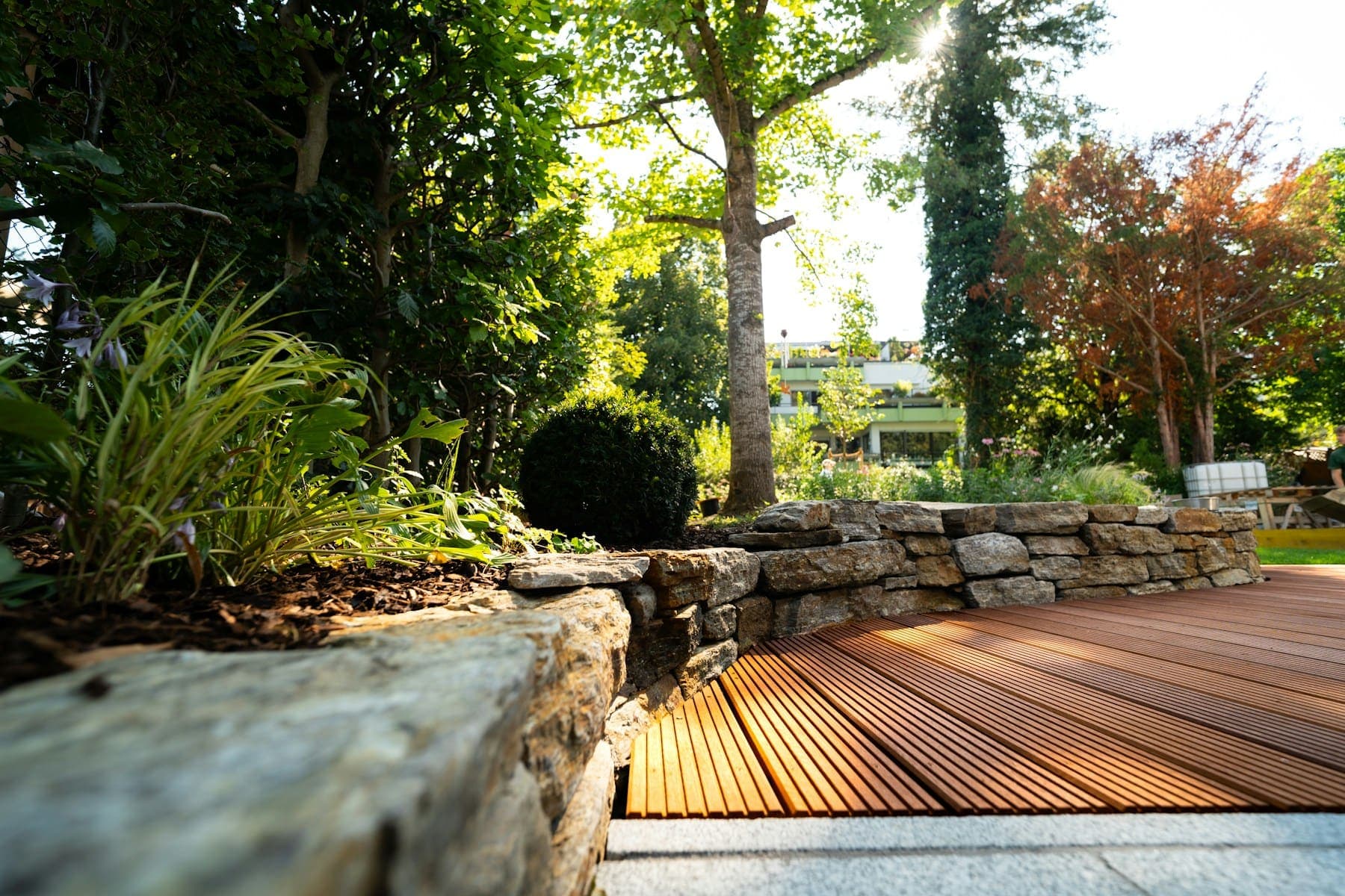 Hardwood deck meeting a dry-stone retaining wall with planting