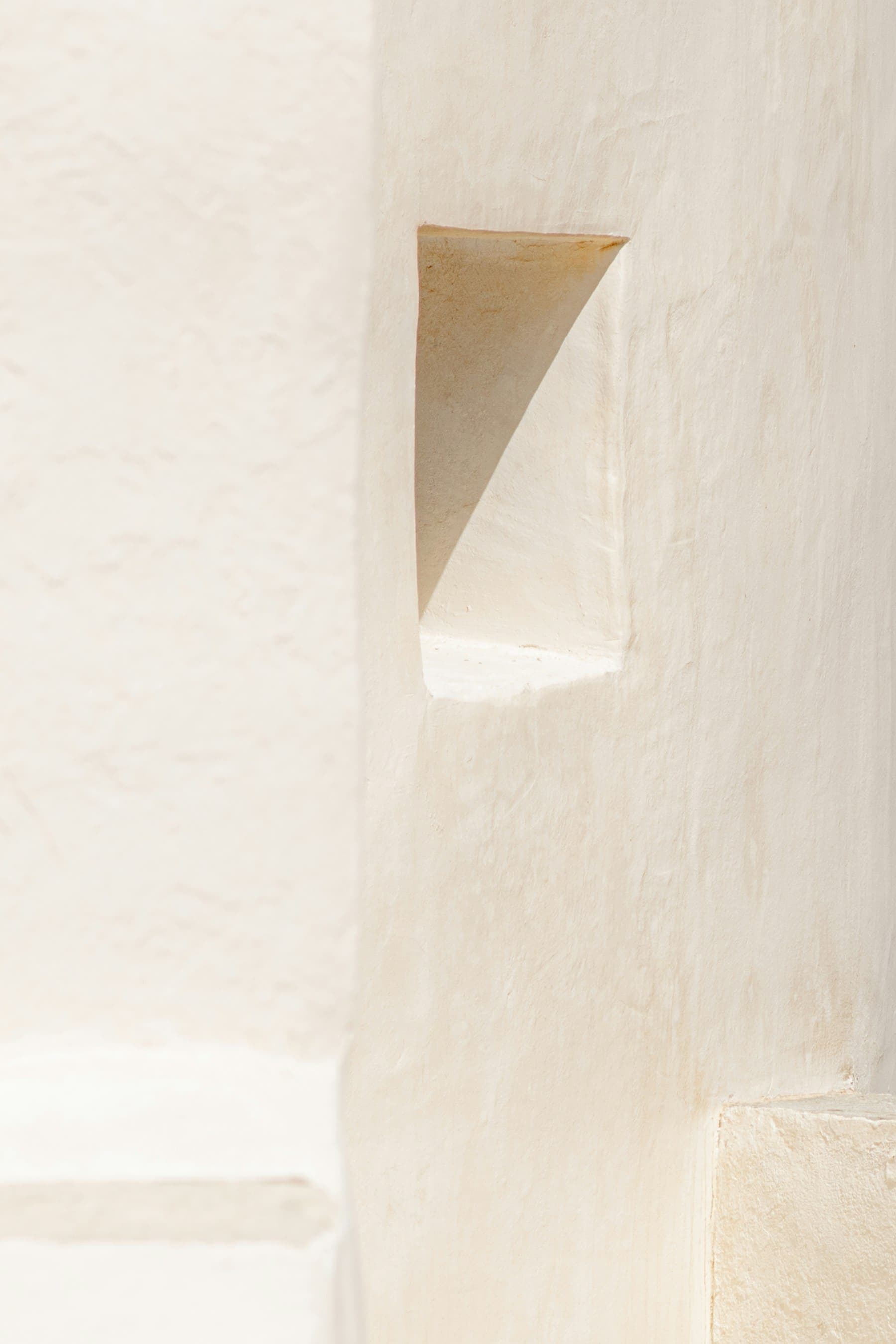 Soft light falling across a cream plaster wall detail