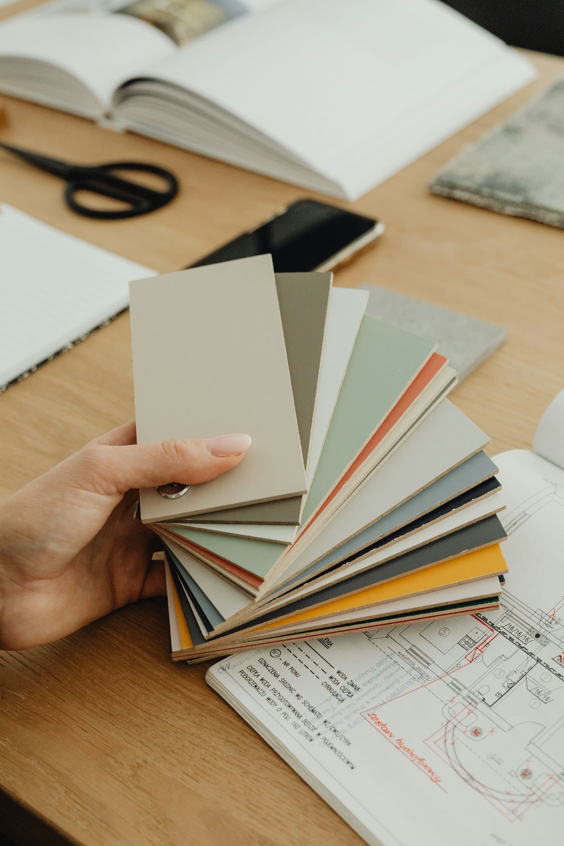 Hand fanning out a deck of muted colour swatches