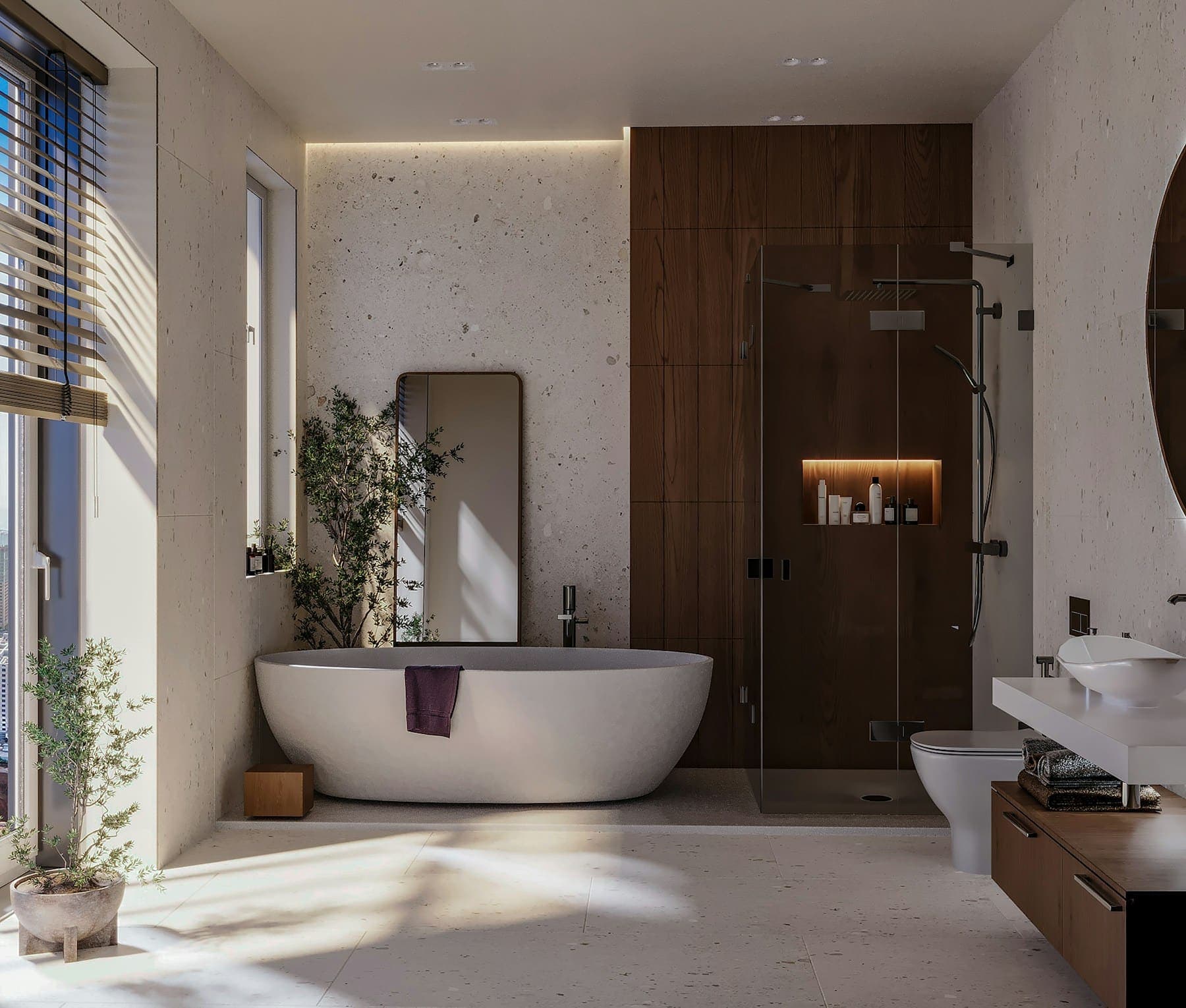 Freestanding bath beneath a large window in a pale stone bathroom